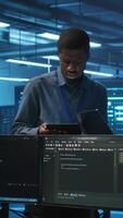 Vertical Multiracial team of technicians working in high tech server hub capable of storing vast amounts of data. Coworkers doing brainstorming, trying to troubleshoot servers controlling network resources video