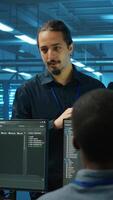 Vertical Manager supervising multiethnic team working in data center ensuring optimal performance. Supervisor and employees monitoring energy consumption across server rigs components video