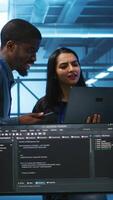 Vertical Technician and team leader in server farm looking for equipment misconfigurations affecting performance. Multiethnic coworkers checking data center infrastructure bottlenecks leading to glitches video