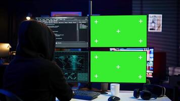 Dangerous man hacking using isolated screen PC, stealing credit card information and breaching banking systems. Hacker running code in apartment on chroma key computer display, close up, camera B video