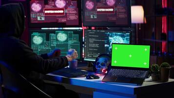Hacker using isolated screen laptop and AI technology to deploy malware on unsecured devices. Scammer stealing sensitive data from unaware users using mockup notebook, camera A video