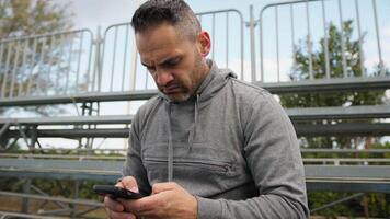Man With Gray Sweatshirt Sends A Message With Phone video