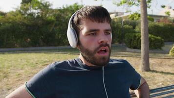 Runner Boy With Headphone Sits On The Bench And Breath Tired After Running video