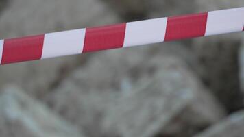Red and white warning tape swinging in the wind. Protection sign. Don't cross the line. Red White caution tape pole fencing is protects for No entry. Backdrop without people, empty street. video