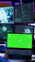 Vertical Hacker in hidden place using green screen laptop to deploy malware on unsecured devices, stealing sensitive data from unaware users online and selling it on black market, camera B video