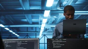 Portrait of happy manager supervising server rows in computer network security data center. Smiling african american supervisor and employees overseeing supercomputers in server hub video