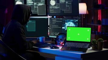verde tela computador portátil usava de hacker dentro subterrâneo esconderijo para escrever linhas do código, em desenvolvimento vírus este pegue passado segurança sistemas. croma chave dispositivo usava de mal desenvolvedor dentro escondido bunker, Câmera uma video
