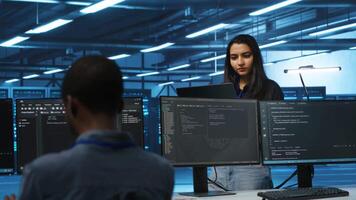 Cheerful supervisor in server room managing multiethnic team of technicians looking for equipment misconfigurations. Upbeat team leader coordinating workers fixing data center malfunctions video