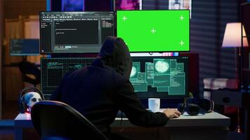 Cybercriminal hacking using green screen PC and getting critical error while trying to steal credit card information. Hacker runs code on mockup computer display, failing to breach firewall, camera A video