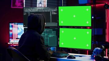 hacker em desenvolvimento spyware Programas em verde tela computador para roubar importante dados para estar vendido em Preto mercado. encapuzado scammer escrevendo malicioso código em croma chave pc, Câmera uma video
