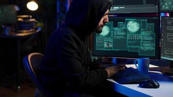 Hacker using PC to steal data, targeting unpatched security systems using malware. Scammer using computer to compromise digital devices, writing rogue script attacking firewalls, camera A video