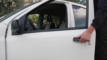 Man Dressed In Black Puts Key Into White Car And Gets In video