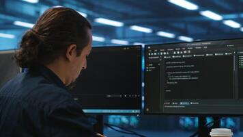 Computer scientist in server hub doing system analysis, coding, doing needed adjustments for supercomputers to run. Expert working in data center housing advanced storage infrastructure video