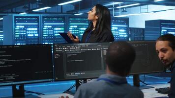 Manager overseeing server room, walking around with checklist on notepad, troubleshooting hardware. Supervisor doing inspection in server hub, monitoring energy consumption across rigs video
