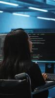 Vertical Woman with impairment next to diverse coworkers in data center coding on computer. Wheelchair user and multiethnic team working together, in inclusive and diverse workspace, doing programming video
