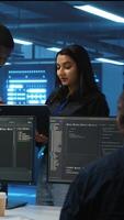 Vertical Manager overseeing server room using laptop to do hardware troubleshooting, talking with multiracial employees. Supervisor doing inspection in data center, receiving performance assessment from worker video