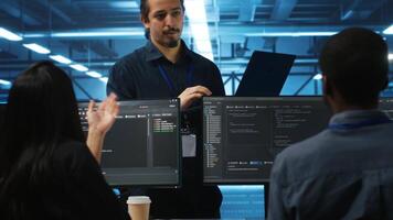 Manager and IT support specialists working together, supervising server rows in computer network security data center. Supervisor and multiethnic employees overseeing supercomputers video