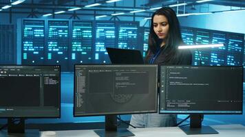 System admin working in computer network security data center, ensuring optimal performance. Worker monitoring energy consumption across operational server racks components video