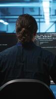 Vertical Engineer drinking coffee and programming in server room with equipment storing datasets. Employee enjoying caffeine beverage, typing code on PC to mend data center racks doing computational operations video