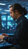Vertical System administrator in server room doing system analysis, coding, doing needed adjustments for supercomputers to run. Specialist working in high tech facility housing advanced storage infrastructure video