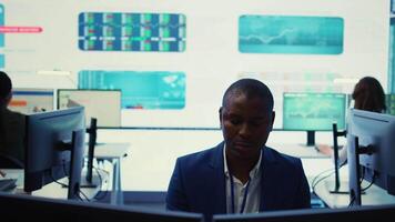 Chief executive officer reviewing project details about achieving business goals, establishing resource allocation. Administrator works in a firm monitoring room with big screen. Camera B. video
