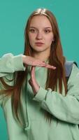 Vertical Portrait of assertive woman asking for timeout, doing hand gestures, feeling fatigued. Unhappy girl doing vehement pause sign gesturing, wishing for break, studio background, camera A video