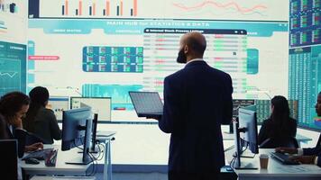 General director employing big data to help in solving tasks in control room, operating on huge screen to create a performance metrics analysis. Manager ensuring organizational efficiency. Camera B. video