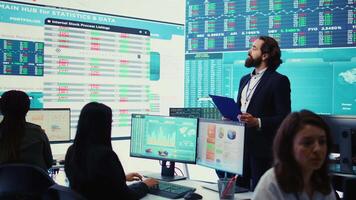 Chief executive officer reviews data shown on big display in the office, screens with infographics, finance analysis and organizational progress. Telecommunications system control room. Camera B. video
