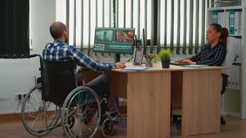 Team of videographers working at project creating content, man blogger sitting in wheelchair in modern company office. Disabled freelancer editing footage postproduction in studio. video