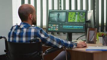 Disabled freelancer videographer editing postproduction a project creating content sitting in wheelchair in modern company office. Creator blogger working from modern photo studio. video