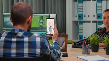 Disabled freelance videographer talking on call with doctor in work time while creates content sitting in wheelchair in modern company office. Creator blogger working from photo studio. video