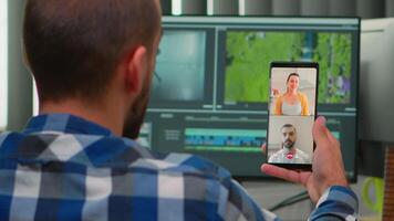 Freelancer editor with disability in wheelchair having videocall while editing postproduction an project creating content in modern company office. Videographer working from photo studio video
