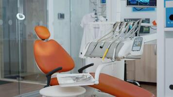 Close up of dental chiar in empty dentist stomatology hospital office with nobody in it. Orthodontic medical cabient with professional oral teeth instrument ready for healthcare treatment video