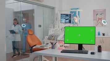 Horizontal green screen on computer in dentist office while specialists using equipment for dental care. Monitor with chroma key and isolated mockup template in office for teethcare. video