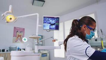Pov of dentist working on patient mouth hygine in dental office checking teeth problems. Doctor examining in orthodontic office with light lamp and sterilized utensils, close-up face in medical mask. video