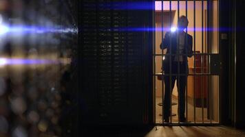 Man in suit spies Investigating vault safe holding a flashlight in dark room video