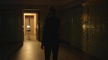 A mysterious man with a flashlight in a dark vault corridor, creating a suspenseful scene video