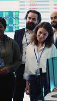 Vertical Professional forecast affiliates group posing in monitoring room, making crucial decisions together to ensure objectives accomplishment and work on international business expansion. Camera A. video