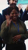 Vertical Confident smiling enterprise team uniting their forces to improve workflow and efficiency, achieve organizational goals. Diverse group of analysts work in telecommunications control room. Camera A. video