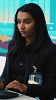 Vertical Indian company analyst reviews feedback on sales and orders to work on future improvements, working with statistics on a big screen. Developing marketing and PR strategies. Camera A. video