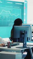Vertical Team of diverse business consultants study feedback on old projects to improve their work for the future, developing new strategies in coworking space monitoring room. Startup activity. Camera A. video