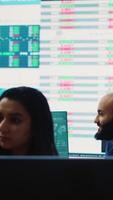 Vertical Company employees employing big data used in solving tasks, studying infographics on a huge display. Business analysts reviewing current situation numbers for annual reports. Camera A. video