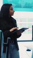 Vertical Enterprise manager looking into project updates and details in monitoring room, establishing resource allocation plans to achieve strategic business goals. Corporation operations. Camera A. video