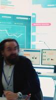 Vertical Business administrator celebrating expansion progress with his team, jumping around in the organizational coworking space. CEO is pleased about new fruitful investment and collaboration. Camera A. video