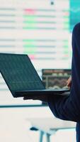 Vertical General director employing big data to help in solving tasks in control room, operating on huge screen to create a performance metrics analysis. Manager ensuring organizational efficiency. Camera A. video