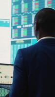 Vertical Administrative assistant examining important big data visualizations on a huge display, creating an analysis to review key performance indicators and business efficiency. Camera A. video