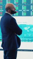 Vertical General manager and CEO sharing insight about a new development strategy with data on a big screen, presenting annual infographics to analyze business activity status. Investors team. Camera A. video