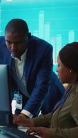 Vertical Financial analyst works on resource allocation plans with his staff, analyzing reports and sales infographics to find revenue. Achieve objectives in a competitive business environment. Camera A. video