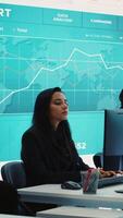 Vertical Corporate analysts looking into project details and timetables, team leader providing flyers with budget and operations plan to achieve business goals in a competitive environment. Camera A. video
