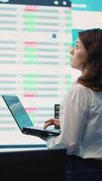 Vertical Member of the advisory board examines potential business expansion, supervisor look into data visualizations on a big screen in the office. Seeks to boost affordable earnings. Camera A. video